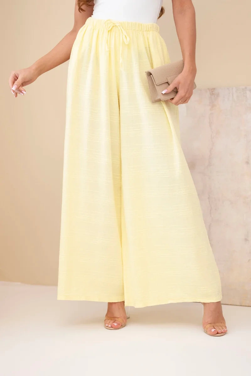 damskie spodnie szerokie bawełniane w pastelowym różu z elastyczną gumką w pasie