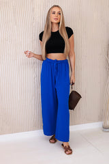 damskie spodnie pomarańczowe z wiązaniem w pasie, zbliżenie na materiał